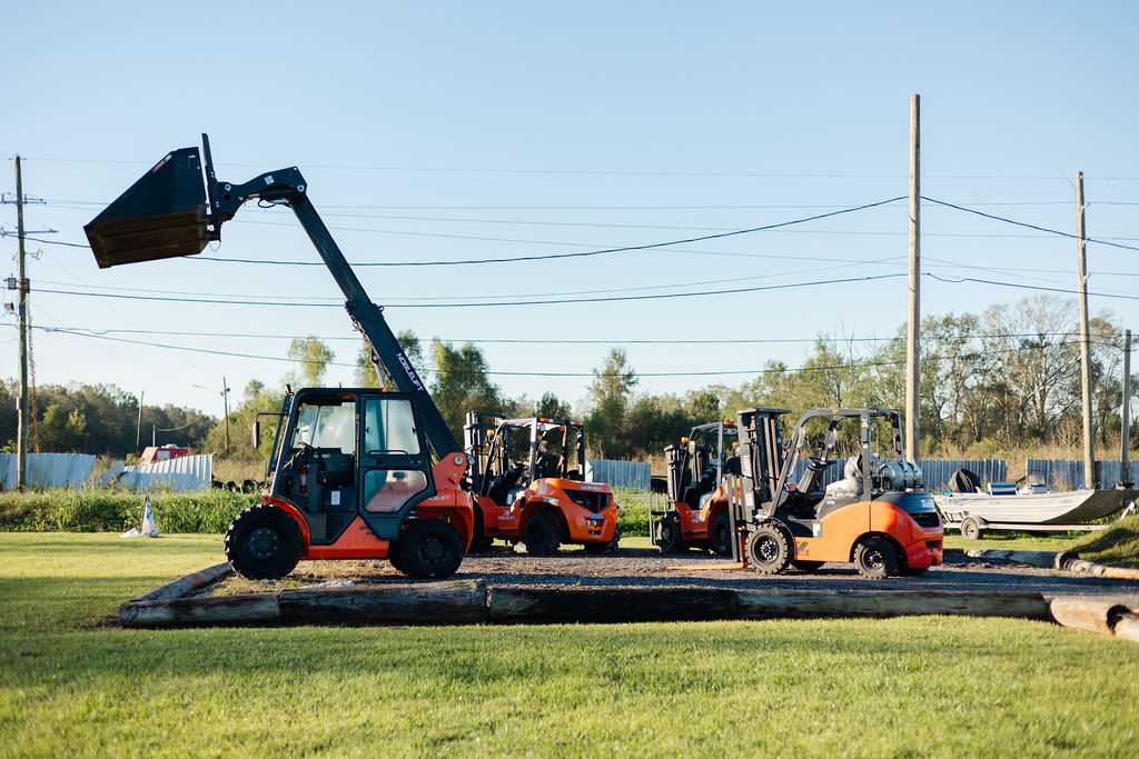 Lineup of Bolton Equipment Services forklifts and a Noblelift rough-terrain telehandler with boom extended at the South Louisiana yard