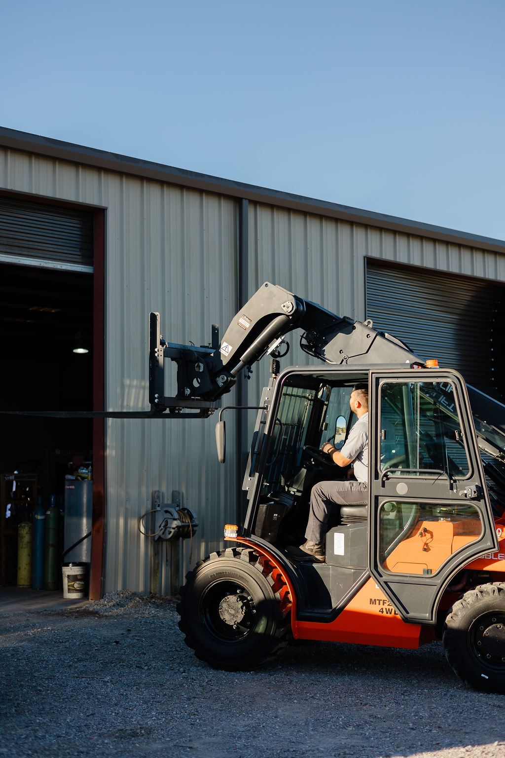 Bolton Equipment technician operating a 4WD rough terrain telehandler outside the Thibodaux shop