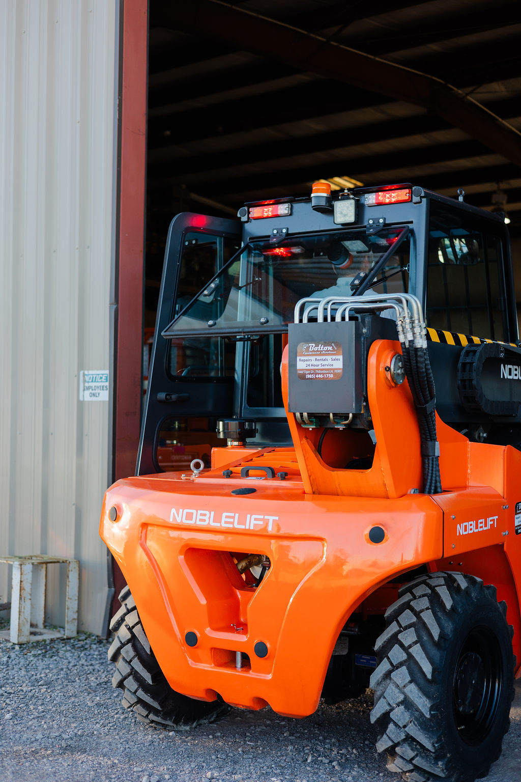 Two Noblelift forklifts parked at the Bolton Equipment service bay door