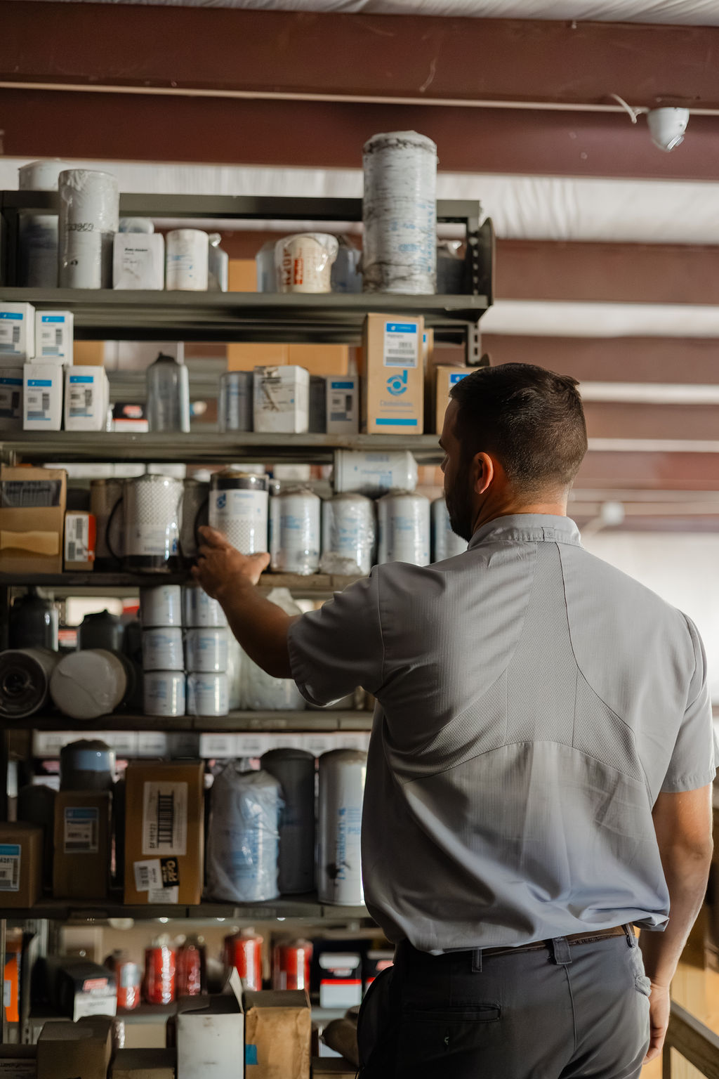 Bolton parts manager pulling a filter from the parts shelves at the Thibodaux shop